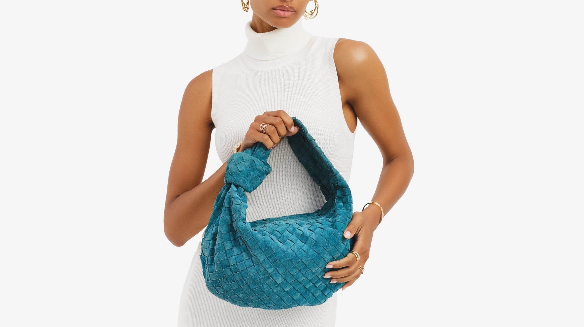 Woman holds a suede Bottega Veneta Jodie
