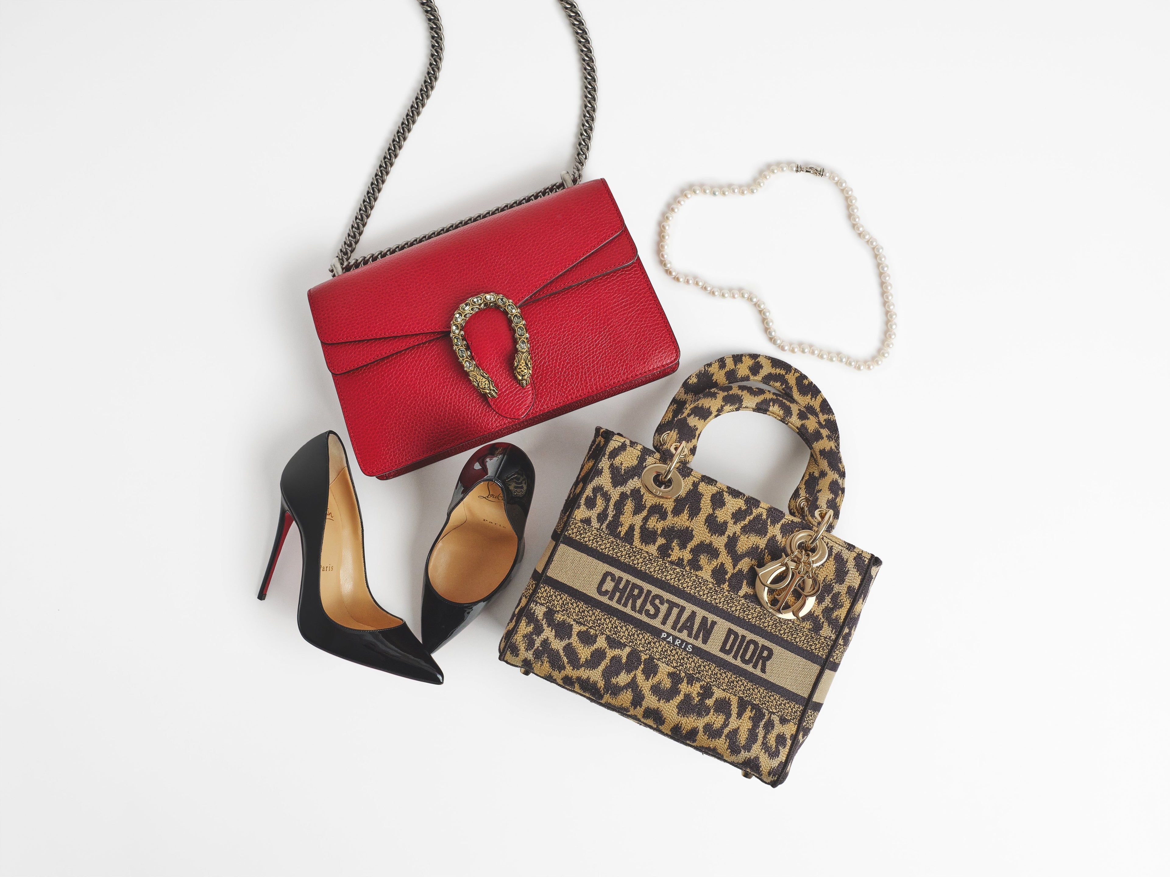 Image of a leopard print Christian Dior Book Tote, a Gucci Dionysus Shoulder Bag in Hibiscus Red, Christian Louboutin Patent So Kate 120 Pumps, and a David Yurman Sterling Silver Diamond Pearl