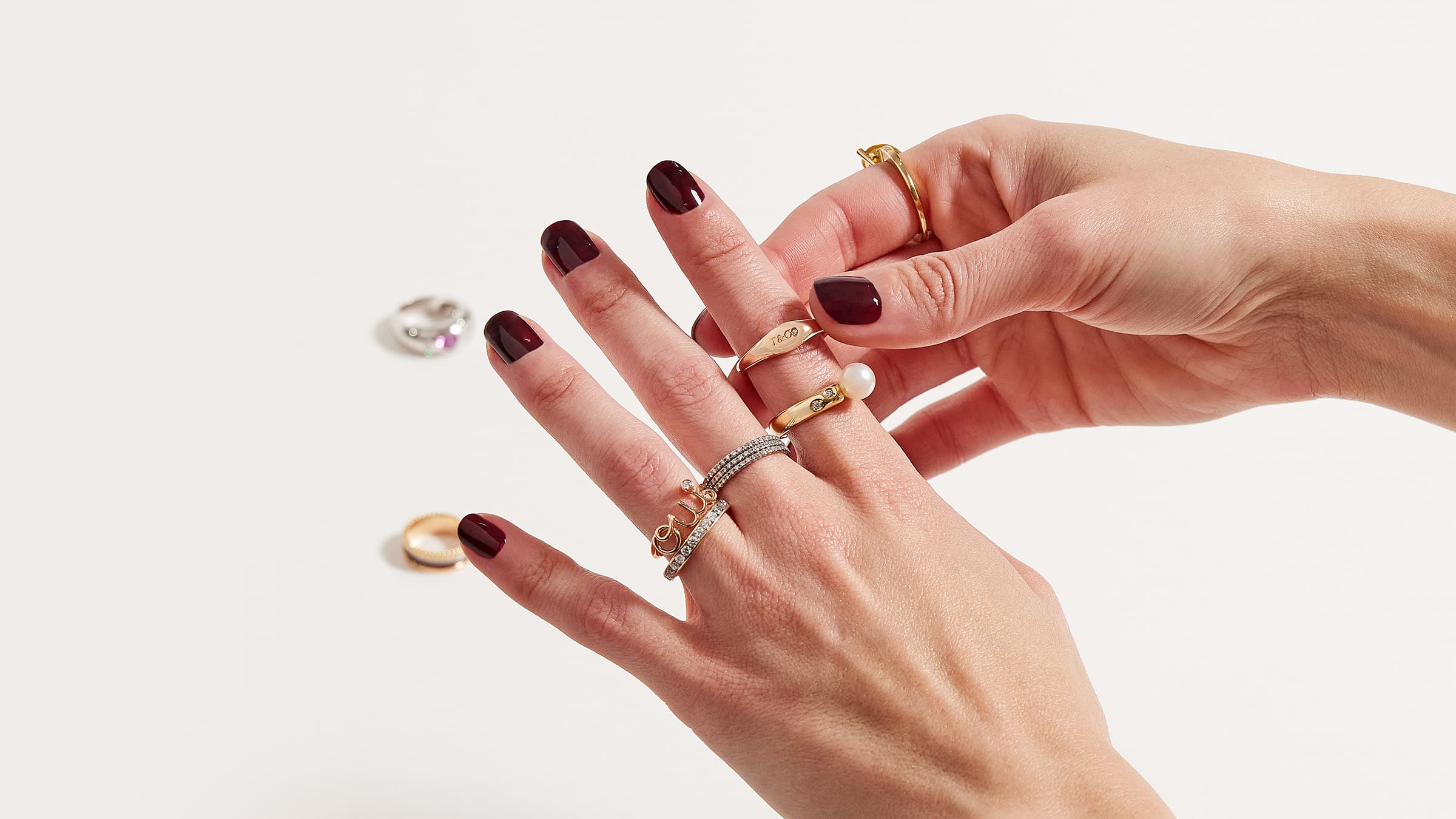 lifestyle image of rings stacked on fingers - 5 Ultra-Luxury Ring Styles: A Buying Guide FASHIONPHILE