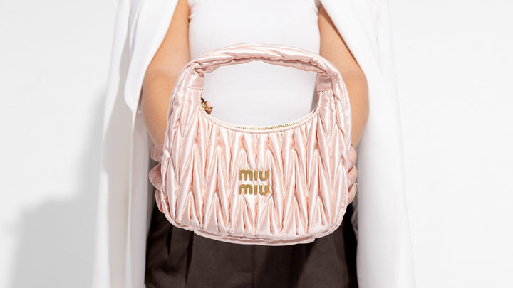 girl holding satin miu miu mini wander bag in pink by fashionphile