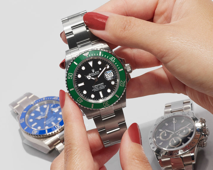 lifestyle image of woman holding Rolex Hulk watch with watches in background at FASHIONPHILE