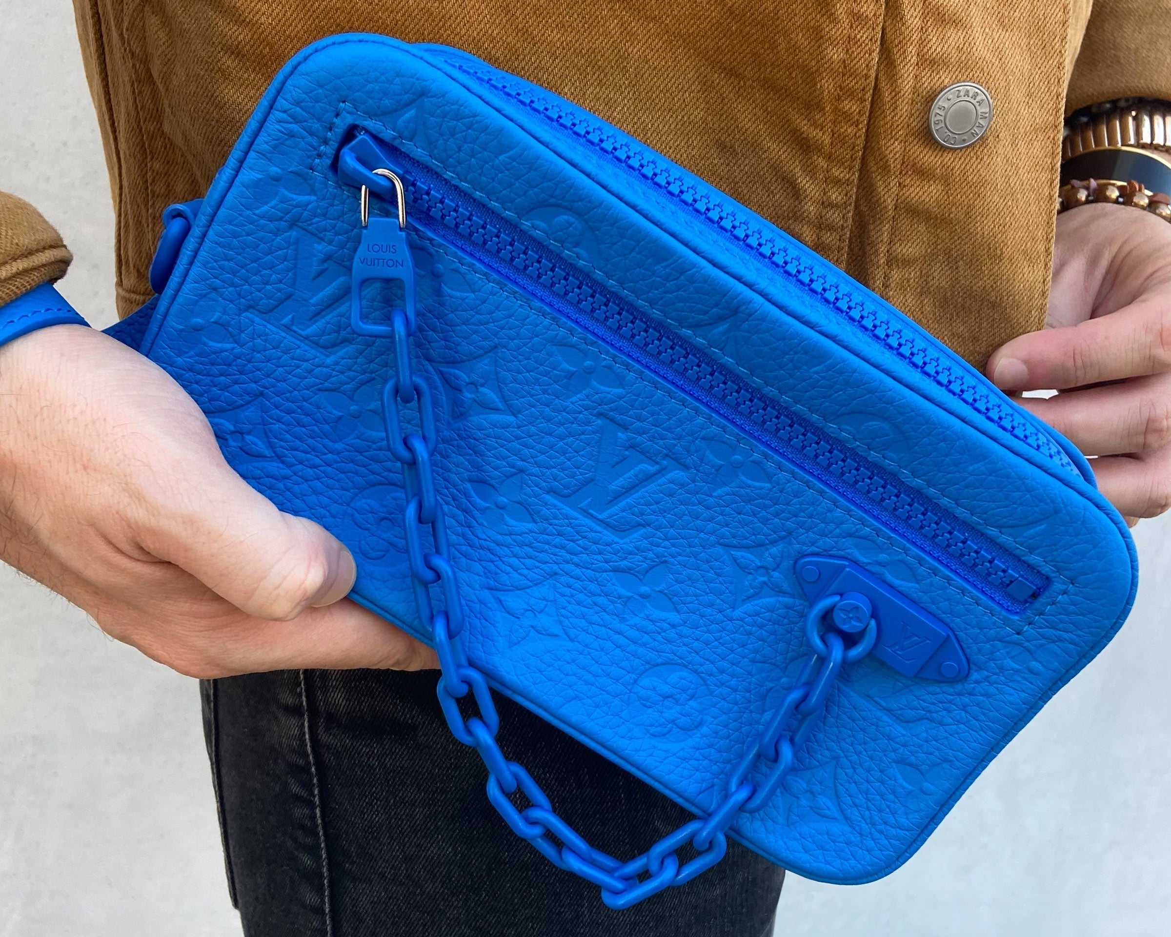 male model influencer wearing the blue leather Louis Vuitton Volga wrist bag FASHIONPHILE