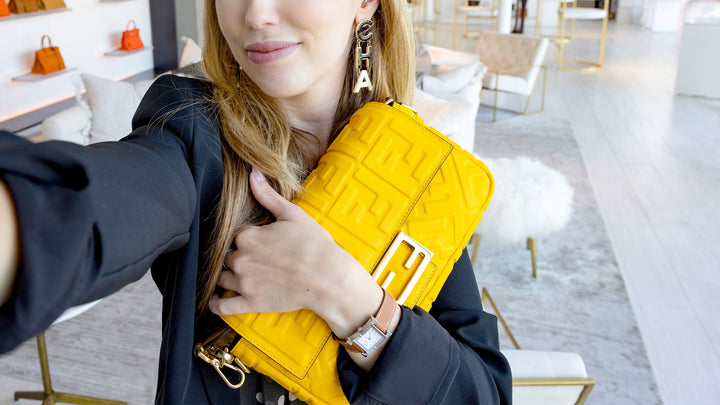 selfie image of girl holding a yellow fendi baguette inside the fashionphile flagship in san diego carlsbad