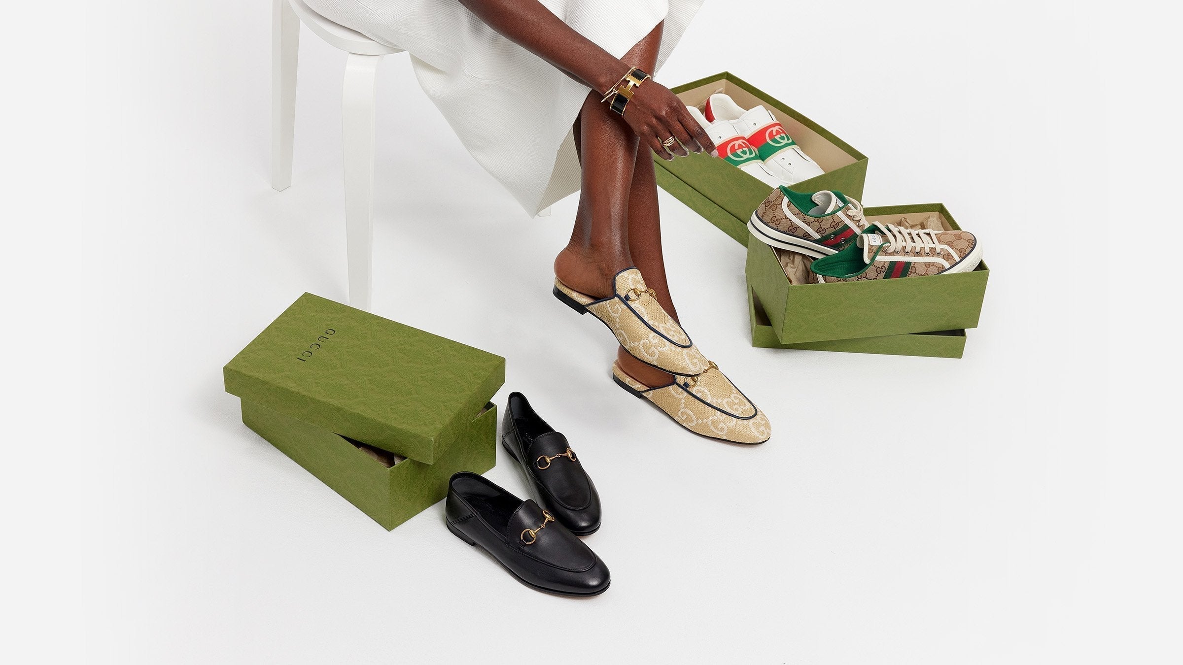 image of gucci loafers, sneakers, and slippers with green gucci shoe boxes by fashionphile