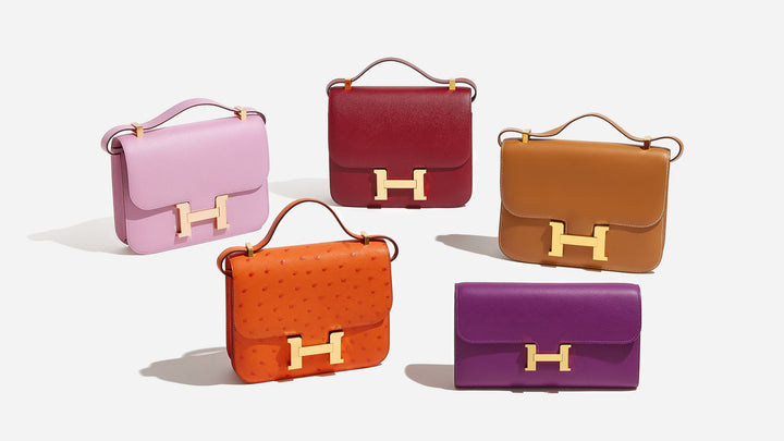 a group of different colored hermes constance bag styles by FASHIONPHILE