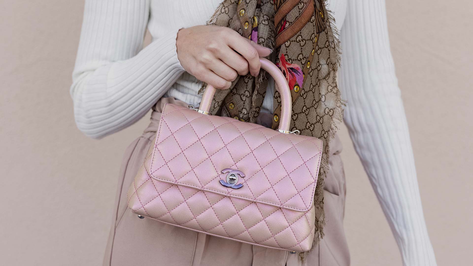lifestyle image of model holding chanel iridescent coco handle bag FASHIONPHILE