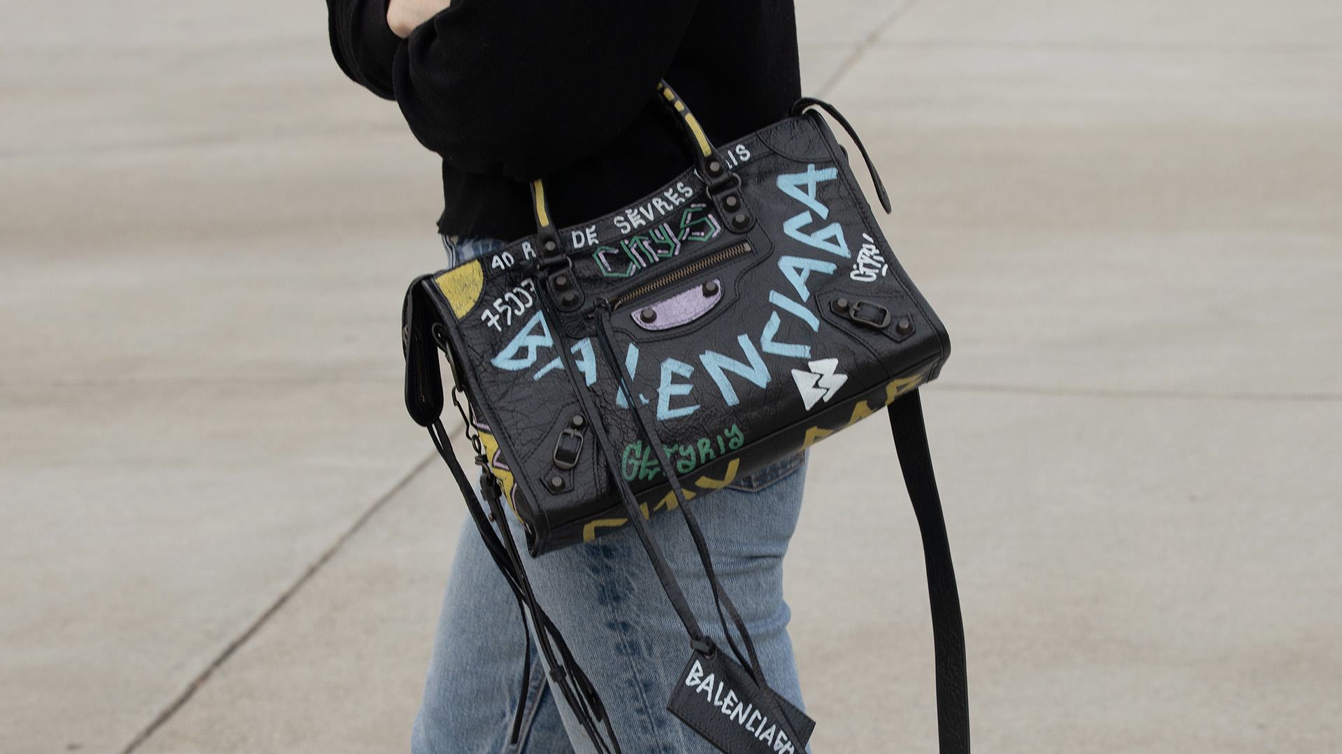 lifestyle image of model wearing graffiti balenciaga city bag FASHIONPHILE