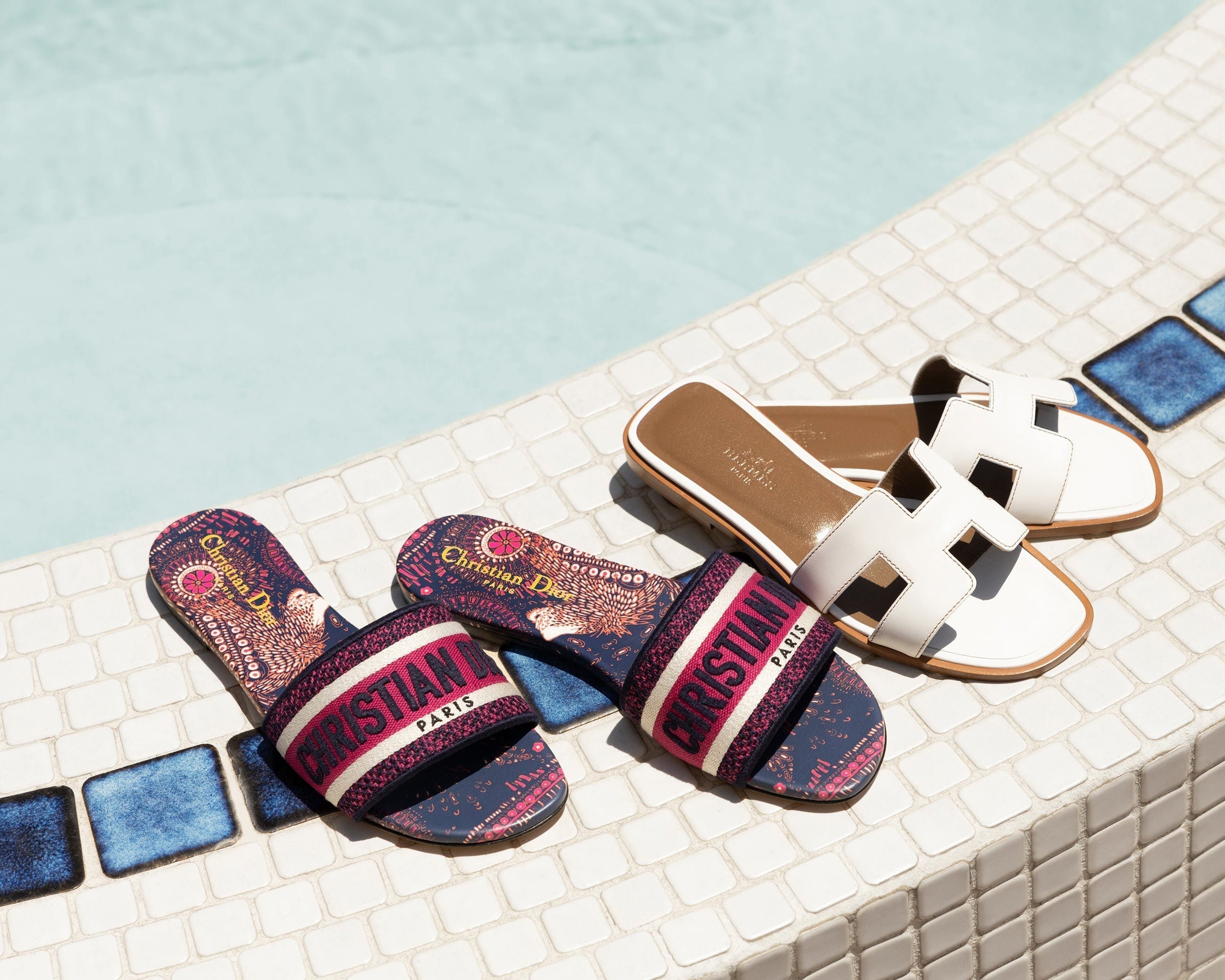 Lifestyle image of Christian Dior Dway Sandals and Hermes Oran Sandals outside by the pool