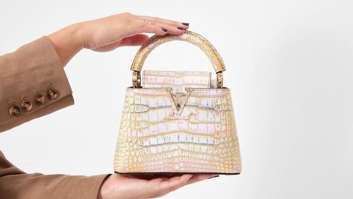 model holding a crocodile louis vuitton mini capucines bag by FASHIONPHILE