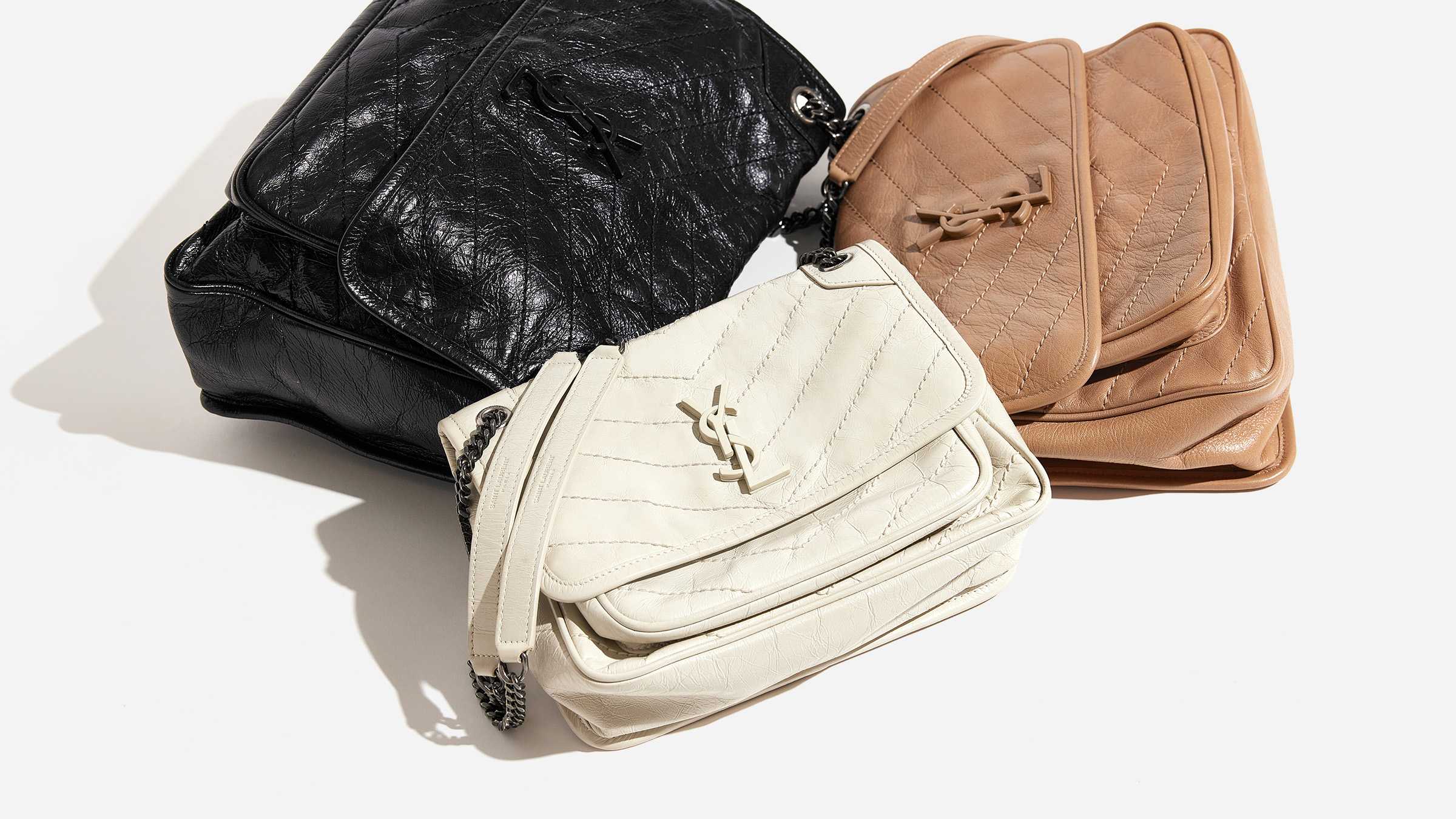 this is a laydown image of all three saint laurent niki chain satchel sizes grouped together by FASHIONPHILE