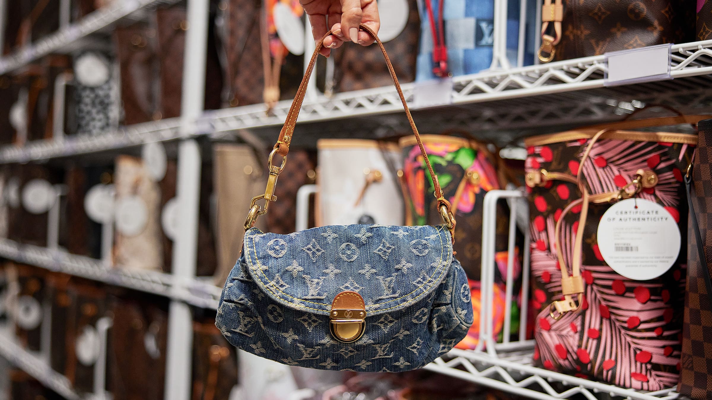 lifestyle image of denim louis vuitton bag inside the FASHIONPHILE cage