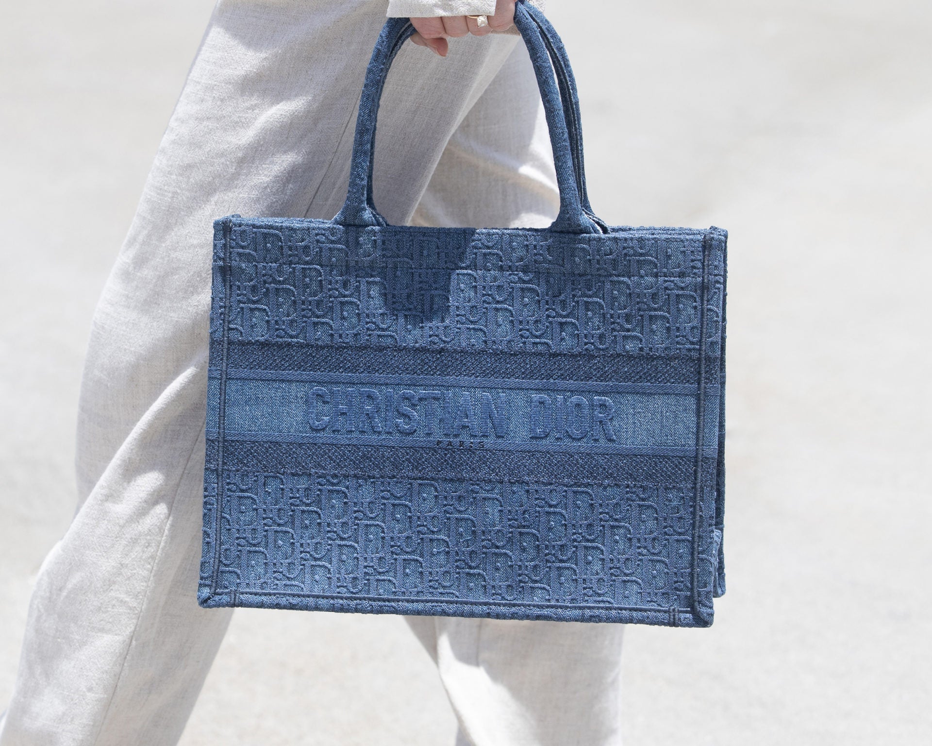 lifestyle image of model holding christian dior book tote FASHIONPHILE